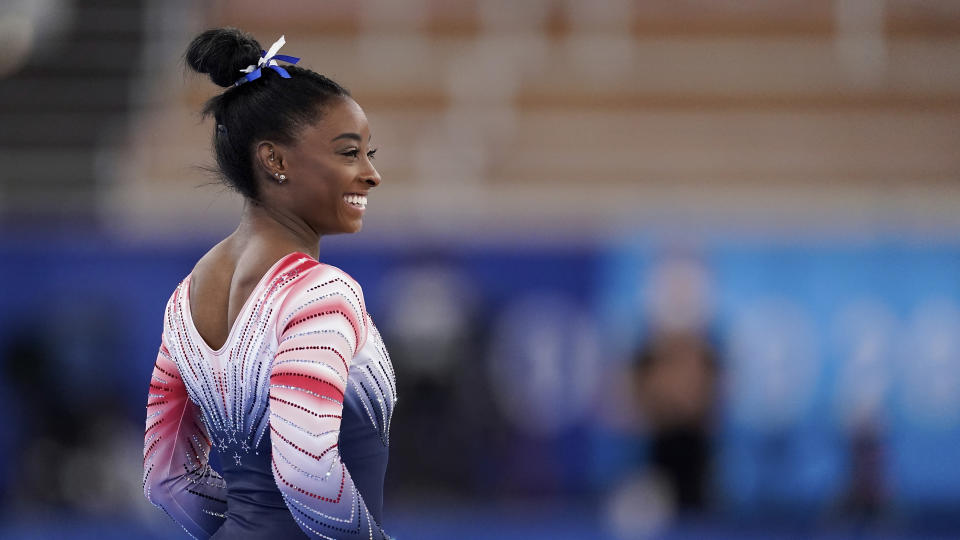 Simone Biles, of the United States, smiles during the warm up prior to the artistic gymnastics balance beam final at the 2020 Summer Olympics, Tuesday, Aug. 3, 2021, in Tokyo, Japan. (AP Photo/Ashley Landis)