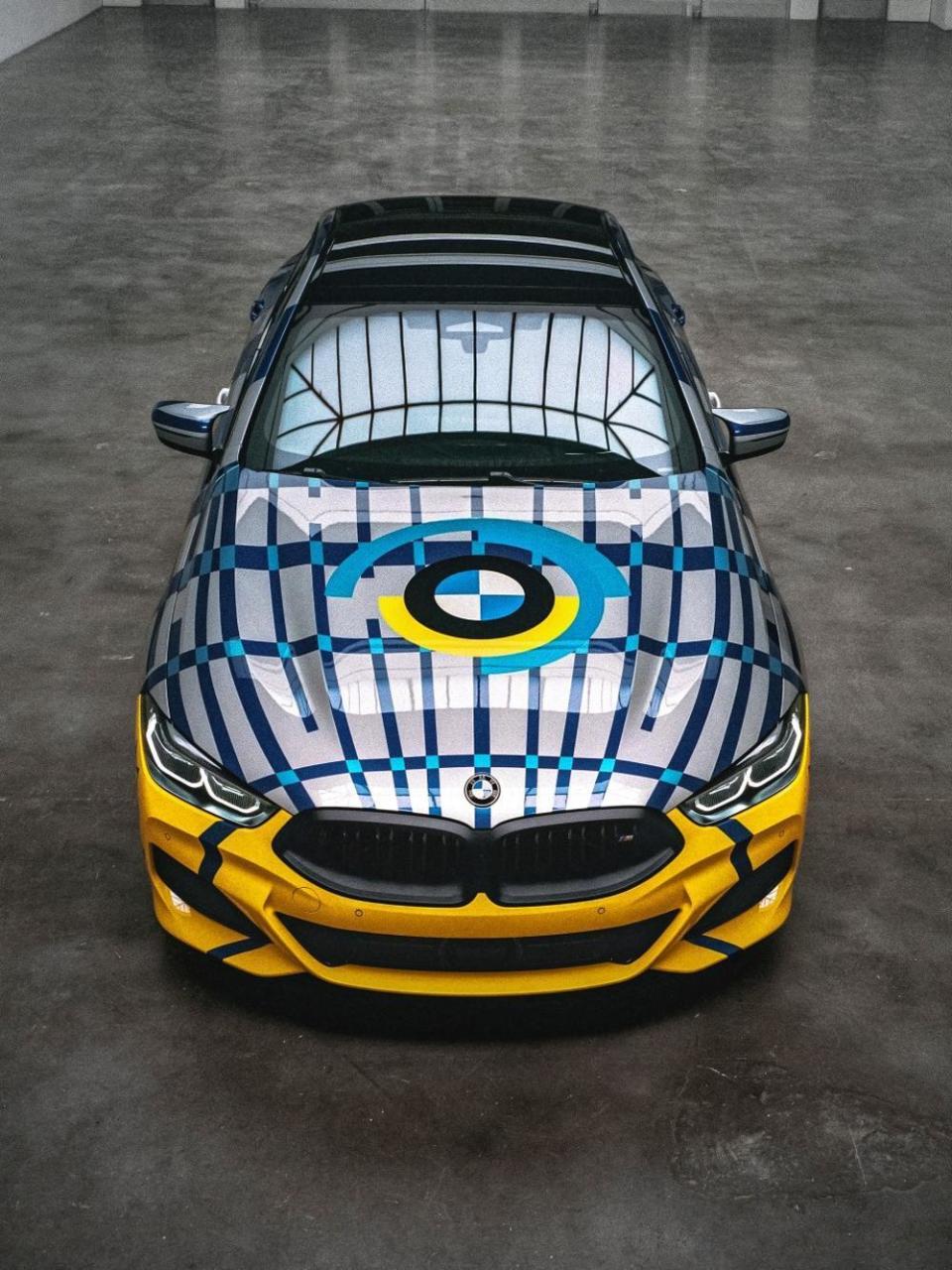 THE 8 Gran Coupé四門旗艦跑車優美的流線車身線條以及極致工藝美學，經Jeff Koons之手加入了大膽前衛的普普藝術風格，鮮明跳動的色彩與狂放複雜的幾何圖型，顛覆眾人的想像。