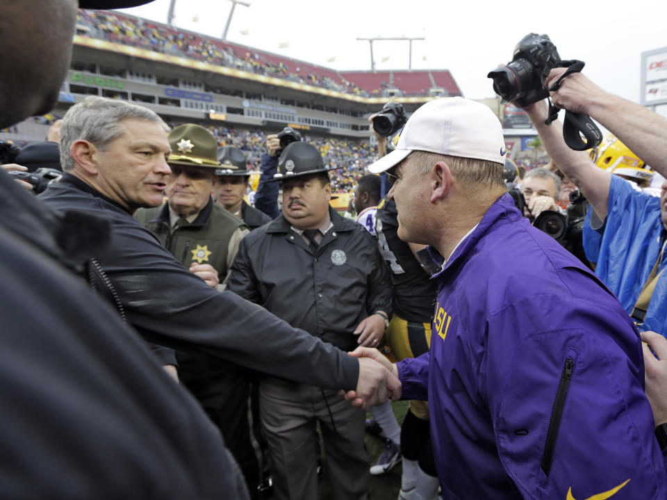 LSU head coach Les Miles, right, shakes hands with Iowa head coach Kirk Ferentz after LSU defeated Iowa 21-14 in the Outback Bowl NCAA college football game Wednesday, Jan. 1, 2014, in Tampa, Fla. (AP Photo/Chris O'Meara)