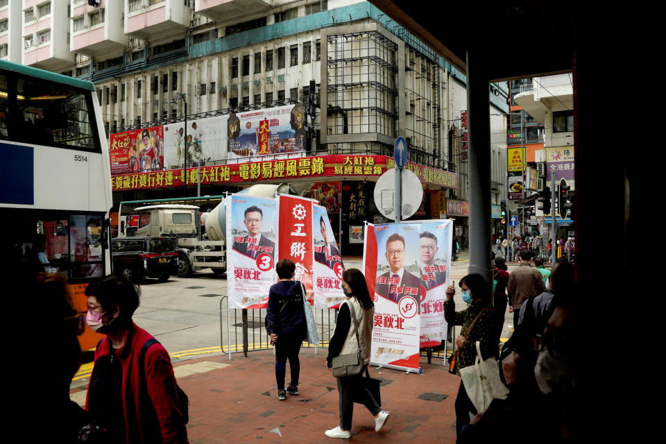 Image: Pedestrians walk past advertisements promoting FTU candidate Stanley Ng Chau-pei before the Legislative Council election in Hong Kong (Lam Yik / Reuters)