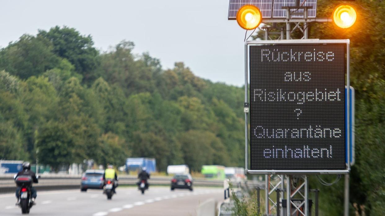 Auf der Autobahn A7 werden Reisende aus Risikogebieten mit einer Leuchttafel "Rückreise aus Risikogebiet? Quarantäne einhalten!" auf die notwendigen Quarantänemaßnahmen hingewiesen.