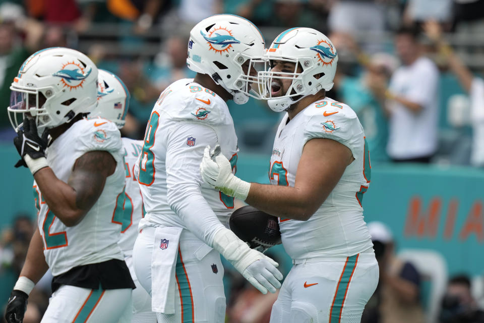 Miami Dolphins defensive tackle Zach Sieler (92) celebrates with defensive tackle Raekwon Davis (98) after Sieler picked up a fumble by New York Jets quarterback Zach Wilson (2) during the first half of an NFL football game, Sunday, Dec. 17, 2023, in Miami Gardens, Fla. (AP Photo/Lynne Sladky)