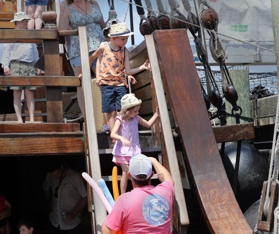 Children and other people take their time on the narrow stairways the three-masted Trinidad July 28, 2023, as Sail Portsmouth tall ship festival is underway for tours and other acitivities.