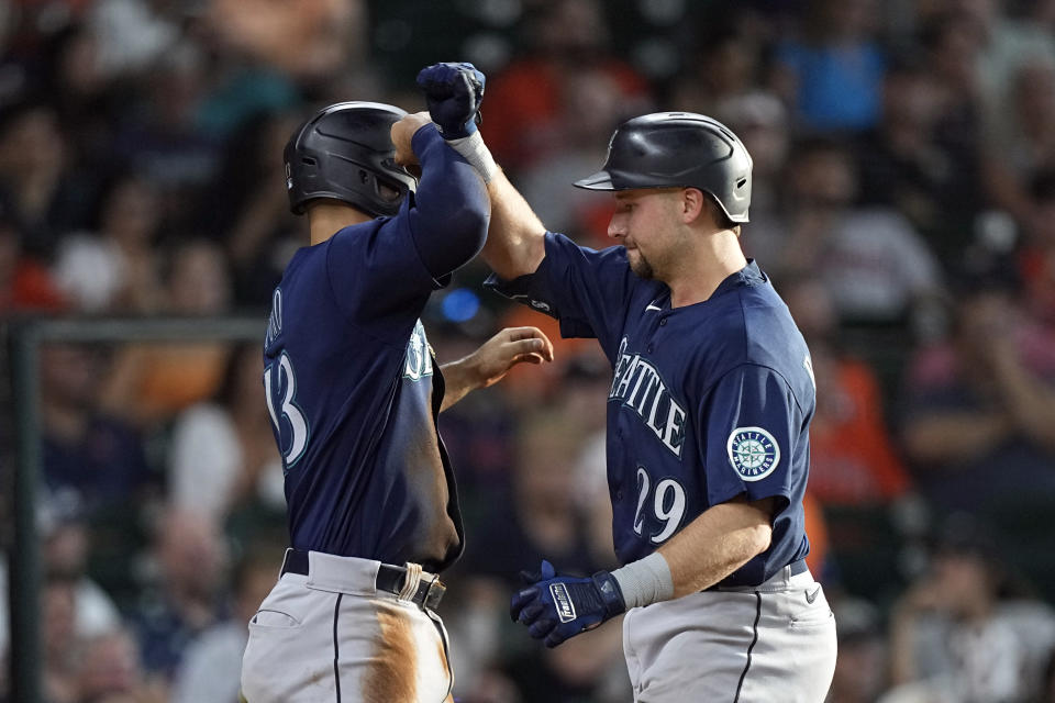 Seattle Mariners' Cal Raleigh (29) celebrates with Abraham Toro after both scored on Raleigh's home run against the Houston Astros during the fourth inning of a baseball game Wednesday, June 8, 2022, in Houston. (AP Photo/David J. Phillip)