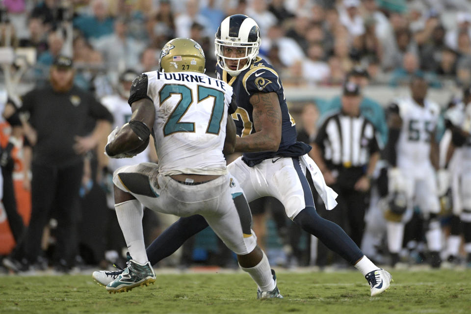 Jaguars running back Leonard Fournette (27) plants his right leg awkwardly in front of Rams cornerback Trumaine Johnson while trying to make a cut. (AP) 