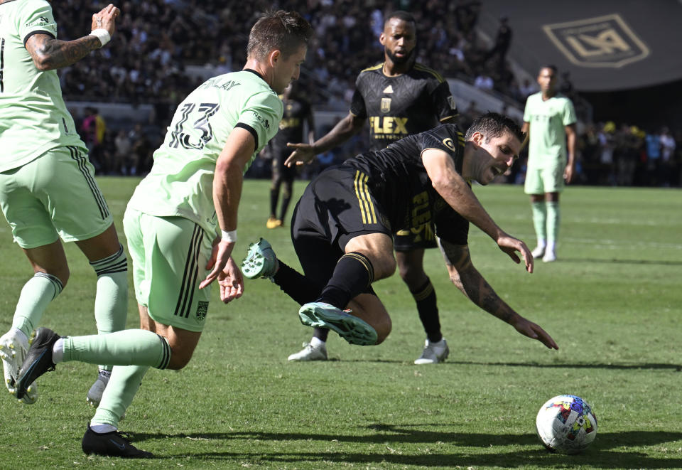 Austin FC midfielder Ethan Finlay, front left, trips Los Angeles FC defender Sebastien Ibeagha, front right, during the second half of an MLS playoff Western Conference final soccer match Sunday, Oct. 30, 2022, in Los Angeles. (AP Photo/John McCoy)