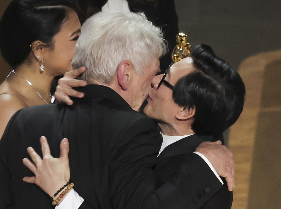 Ke Huy Quan kisses Harrison Ford as he receives the Oscar for Best Picture from him after 