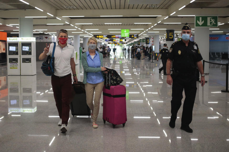 TUI X3 2312 Duesseldorf-Mallorca flight passengers arrive at Son Sant Joan airport in Palma de Mallorca, Spain, Monday, June 15, 2020. Borders opened up across Europe on Monday after three months of coronavirus closures that began chaotically in March. But many restrictions persist, it's unclear how keen Europeans will be to travel this summer and the continent is still closed to Americans, Asians and other international tourists. (AP Photo/Joan Mateu)