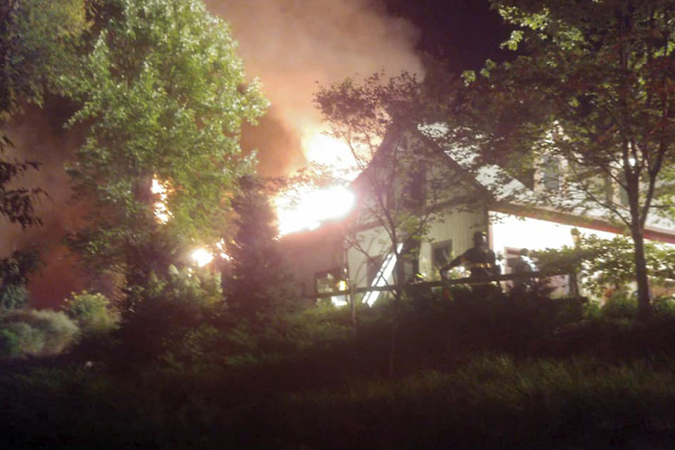 In this Sunday, Aug. 9, 2020 photo, a massive fire engulfs the home of cooking show star Rachael Ray, in Lake Luzerne, NY. Ray's representative said in a statement that Ray, her husband and dog were safe, but that the extent of damage to the home was not yet clear. (Courtesy Kenneth Dickinson via AP)