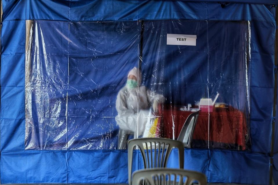 A health worker takes a break at the Covid-19 test site at Dewan Kebajikan Gombak Setia February 20, 2021. — Picture by Ahmad Zamzahuri