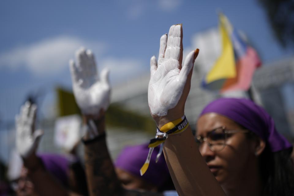 Manifestantes con sus manos pintadas de blanco en la marcha por el Día Internacional de la Mujer en Caracas, Venezuela, el viernes 8 de marzo de 2024. (AP Foto/Ariana Cubillos)