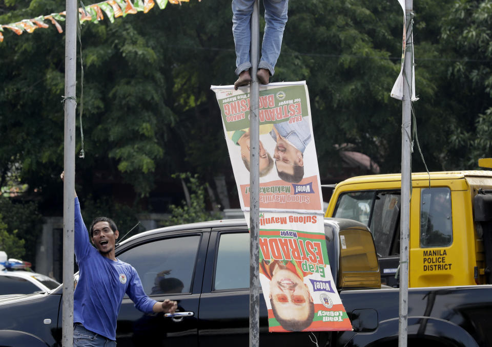 Manila City public workers remove the campaign posters, mostly that of incumbent Mayor and former President Joseph "Erap" Estrada around the Manila City Hall, a day after the country's midterm elections Tuesday, May 14, 2019 in Manila, Philippines. Estrada lost his third term mayoral bid along with four of his children who ran in local polls, ending his 50-year-dominance in two metropolitan cities in the country. Two of his sons, who ran for senators, are also clinging to the last senate slot in initial results, which were dominated by President Rodrigo Duterte's allies. (AP Photo/Bullit Marquez)