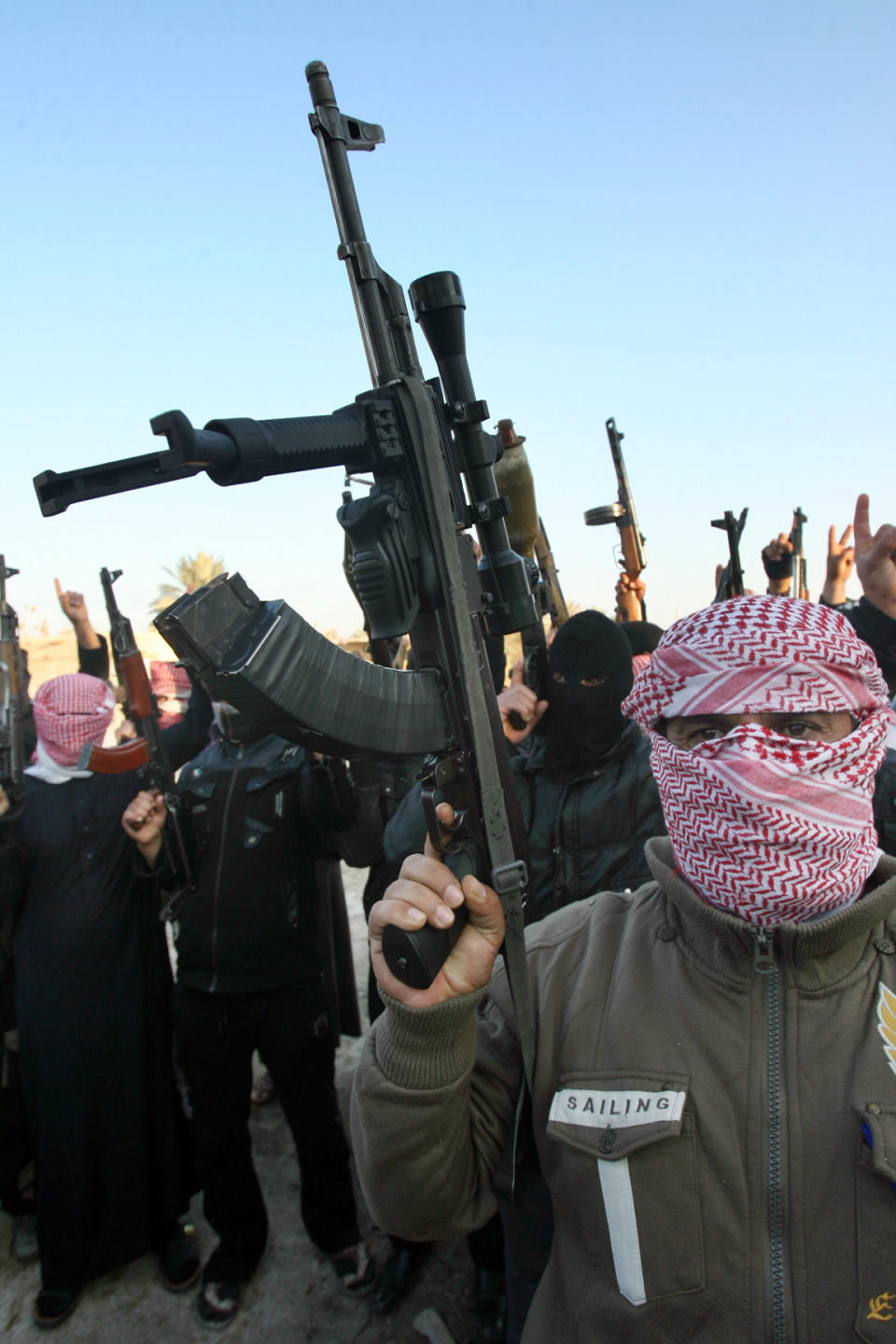 In this Tuesday, Jan. 7, 2014 file photo, gunmen gather in a street as they chant slogans against Iraq's Shiite-led government and demanding that the Iraqi army not try to enter the city in Fallujah, 40 miles (65 kilometers) west of Baghdad, Iraq. Fierce clashes erupted Tuesday between Iraqi special forces and al-Qaida-linked militants outside the city of Fallujah, a flare-up in a days-long standoff in the Sunni-dominated western province of Anbar, Iraqi officials said. (AP Photo)