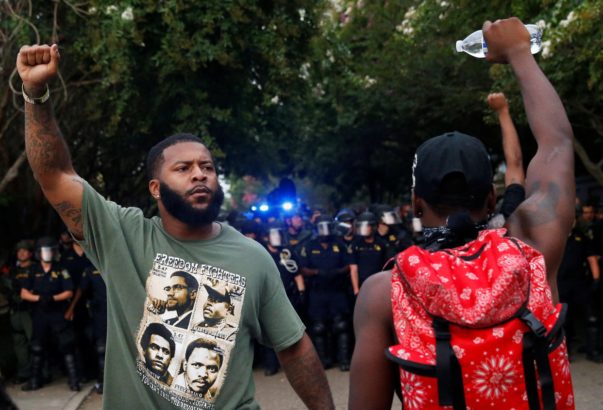 Demonstrators raise their hands in the air as law officials march down a street during protests in Baton Rouge, Louisiana, U.S., July 10, 2016.  REUTERS/Shannon Stapleton