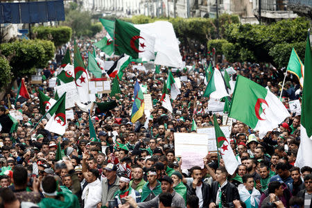 Demonstrators hold flags and banners as they return to the streets to press demands for wholesale democratic change well beyond former president Abdelaziz Bouteflika's resignation, in Algiers, Algeria April 19, 2019. REUTERS/Ramzi Boudina