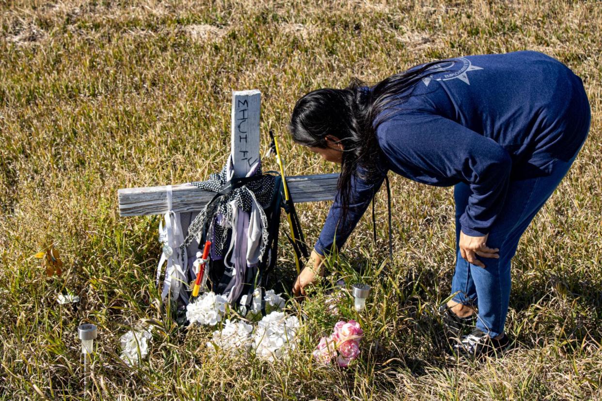 Ronalda Good Shield adjusts her daughter Micheliegh Iron Cloud's memorial cross outside of Parmalee on the Rosebud Reservation. No arrests have been made in connection to Iron Cloud's death.