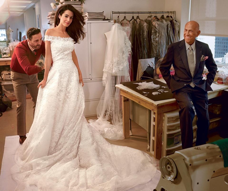 Alamuddin at a final fitting, with Oscar de la Renta (right) and head tailor Raffaele Ilardo, in the designer’s New York studio. Oscar de la Renta ivory beaded-tulle dress with Chantilly-lace appliqué.