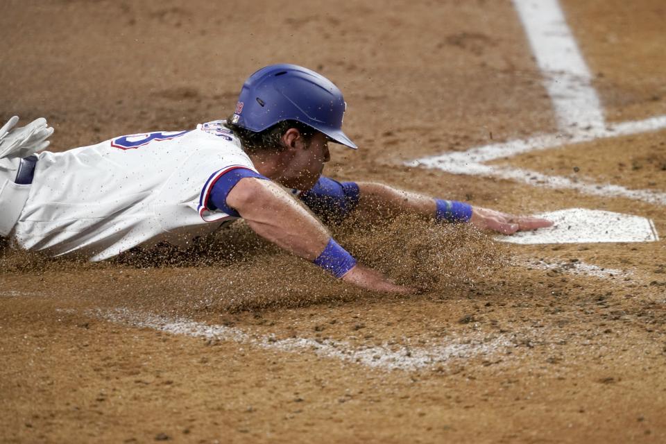 Texas Rangers' DJ Peters slides into home, scoring from first on a single by Curtis Terry during the second inning of the team's baseball game against the Los Angeles Angels in Arlington, Texas, Tuesday, Aug. 3, 2021. (AP Photo/Tony Gutierrez)