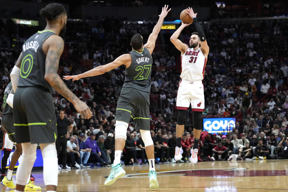 Miami Heat guard Max Strass, 31, takes a shot as Minnesota Timberwolves center Rudy Gobert, 27, defends during the second half of an NBA basketball game in Miami on Monday, Dec. 26, 2022. The Heat won 113-110.  (AP Photo/Lynne Sladky)