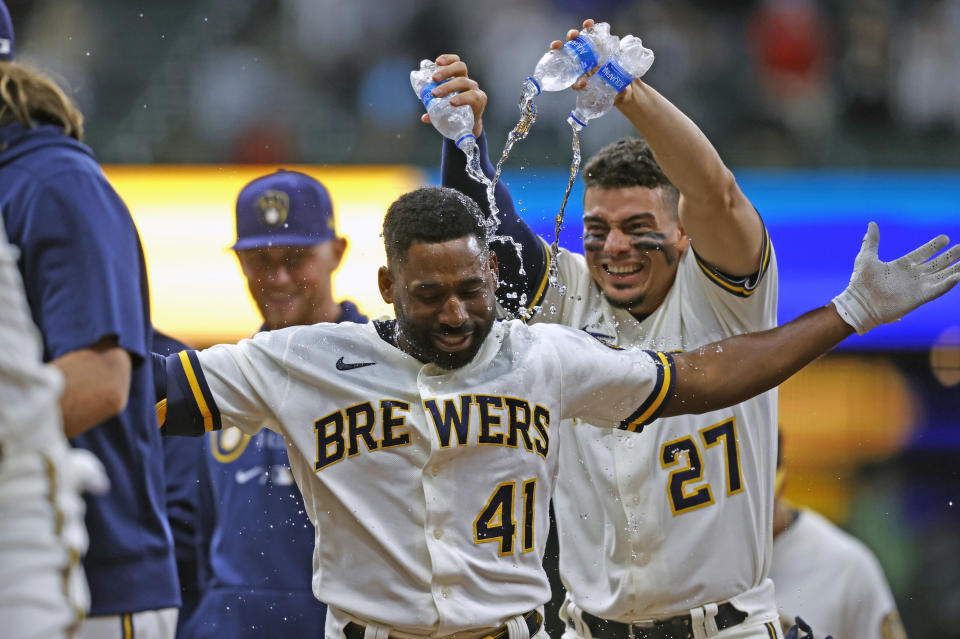 Milwaukee Brewers shortstop Willy Adames (27) showers Milwaukee Brewers center fielder Jackie Bradley Jr. (41) after his game winning single against the San Diego Padres in the tenth inning of a baseball game Thursday, May 27, 2021, in Milwaukee. (AP Photo/Jeffrey Phelps)