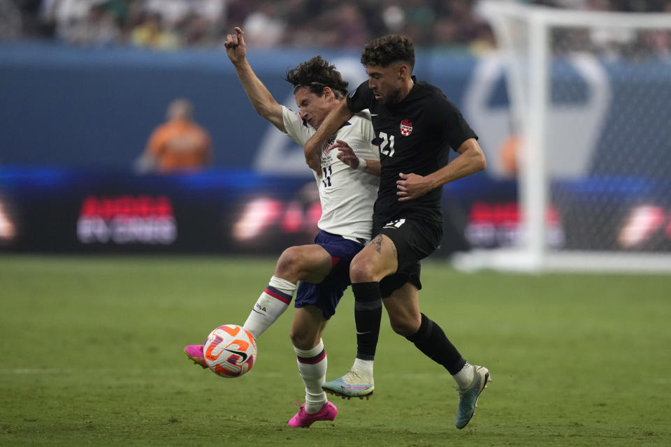 Brenden Aaronson of the United States, left, and Jonathan Osorio, of Canada, battle for the ball during the first half of a CONCACAF Nations League final match Sunday, June 18, 2023, in Las Vegas. (AP Photo/John Locher)