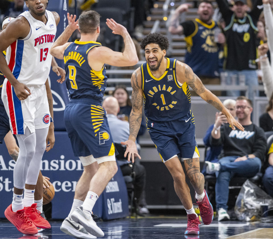 Indiana Pacers forward Obi Toppin (1) reacts after scoring off a pass by guard T.J. McConnell (9) during the second half of an NBA basketball game against the Detroit Pistons in Indianapolis, Thursday, Feb. 22, 2024. (AP Photo/Doug McSchooler)