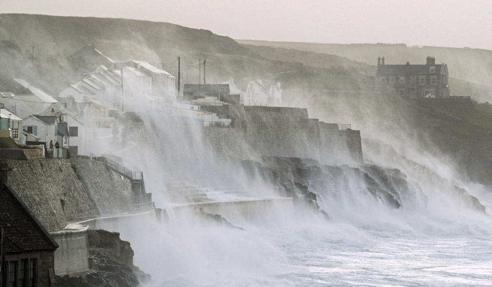 Waves hits Porthleven on the Cornish coast, Britain, as Storm Eunice makes landfall Friday, Feb. 18, 2022. Millions of Britons are being urged to cancel travel plans and stay indoors Friday amid fears of high winds and flying debris as the second major storm this week prompted a rare “red” weather warning across southern England. (Matt Keeble/PA via AP)