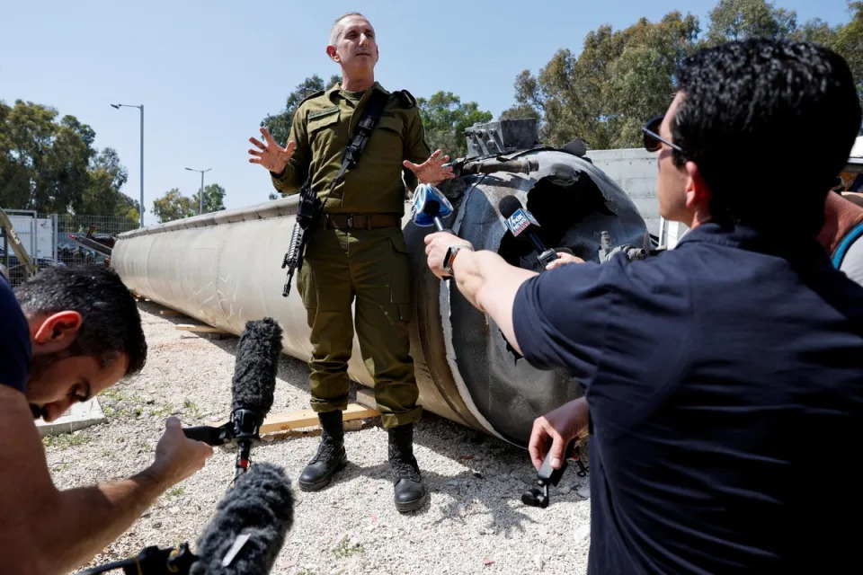 Israeli military spokesperson rear admiral Daniel Hagari stands next to an Iranian ballistic missile which they say was retrieved from the Dead Sea (Reuters)