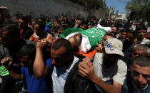 <p>Mourners carry the body of a Palestinian, who was killed during a protest against U.S embassy move to Jerusalem at the Israel-Gaza border, during his funeral in the central Gaza Strip, May 15, 2018. (Photo: Ibraheem Abu Mustafa/Reuters) </p>