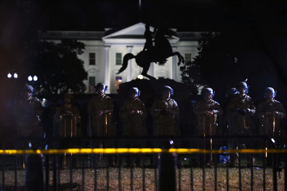 Con la Casa Blanca de fondo, una línea de policías se forma tras una cerca en el Parque Lafayette, mientras los manifestantes se reúnen para protestar por la muerte de George Floyd, el martes 2 de junio de 2020 en Washington. (AP Foto/Evan Vucci)