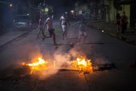 <p>Kinder spielen nachts in einer Straße in Tegucigalpa, Honduras, Fußball. Vor ihnen brennen noch Barrikaden, die regierungskritische Demonstranten während einer Ausgangssperre angezündet hatten. Die Opposition hatte zu einem Protestmarsch aufgerufen, nachdem bei der Präsidentschaftswahl am vergangenen Sonntag über einen Wahlbetrug spekuliert wurde. (Bild: AP Photo/Rodrigo Abd) </p>