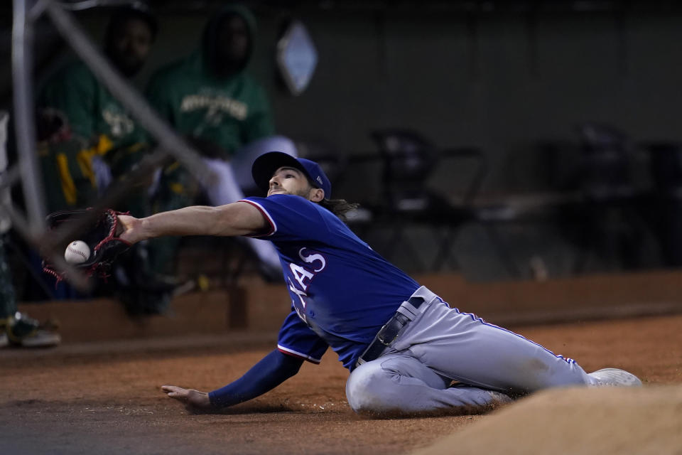 In foul territory, Texas Rangers left fielder Josh Smith catches an RBI-sacrifice fly by Oakland Athletics' Vimael Machin during the seventh inning of a baseball game in Oakland, Calif., Saturday, July 23, 2022. (AP Photo/Jeff Chiu)