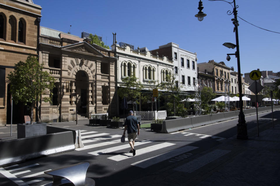 A pedestrian crosses a street in The Rocks area of Sydney, Australia, on Tuesday, Oct. 13, 2020.