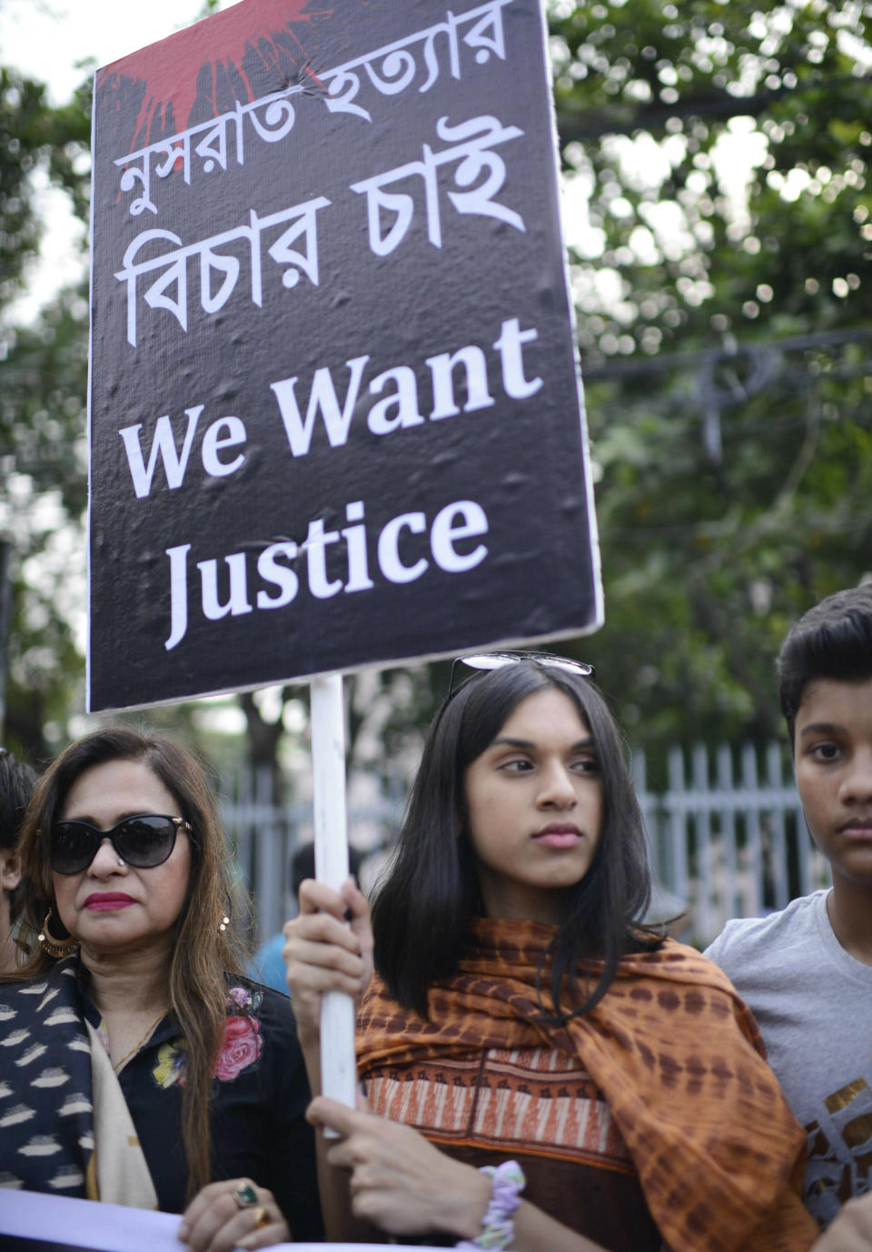 Protesters hold placards and gather to demand justice for an 18-year-old woman who was killed after she was set on fire for refusing to drop sexual harassment charges against her Islamic school's principal, in Dhaka, Bangladesh, Friday, April 19, 2019. Nusrat Jahan Rafi told her family she was lured to the roof of her rural school in the town of Feni on April 6 and asked to withdraw the charges by five people clad in burqas. When she refused, she said her hands were tied and she was doused in kerosene and set alight. Rafi told the story to her brother in an ambulance on the way to the hospital and he recorded her testimony on his mobile phone. She died four days later in a Dhaka hospital with burns covering 80% of her body. (AP Photo/Mahmud Hossain Opu)