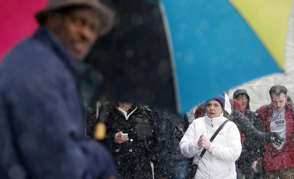 Snow falls on pedestrians walking in downtown Boston, Tuesday, Feb. 18, 2014. It was expected to drop 3 to 5 inches of snow on Boston, with 6 to 10 inches forecast for parts of Northern New England, before moving out late Tuesday and early Wednesday. (AP Photo/Michael Dwyer)