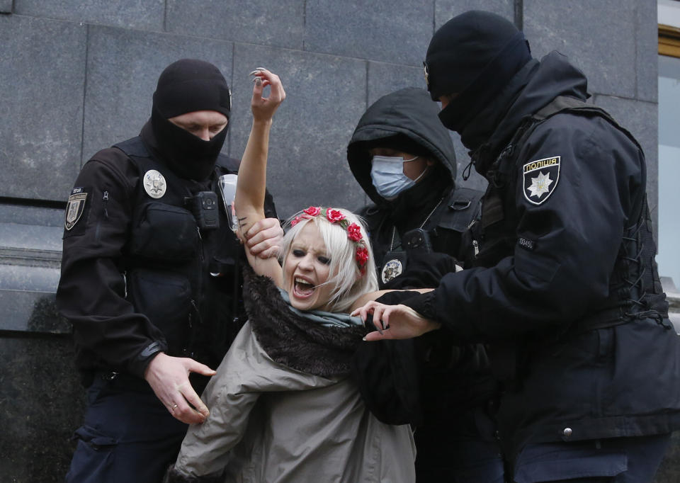 La policía detiene a una activista ucraniana de la organización por los derechos de la mujer "Femen" al conmemorarse el Día Internacional de la Eliminación de la Violencia contra la Mujer el miércoles 25 de noviembre de 2020 mientras protestaba desnuda frente a la oficina presidencial, en Kiev, Ucrania, (AP Foto/Efrem Lukatsky)