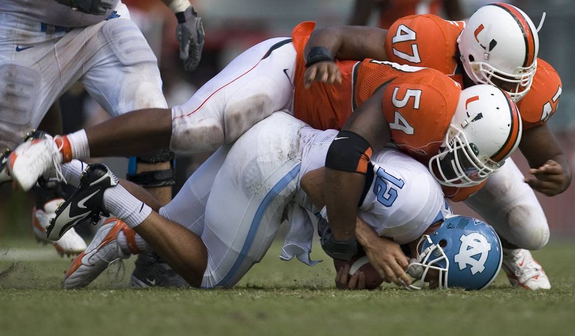 UNCMIAMI3.SP.100706.RTW--Miami, Fla.--UNC quarterback Joe Dailey (12) is sacked for a loss of 11 yards by Miami defensive tackle Teraz McCray (54), and defensive end Vegas Franklin (47) during the fourth quarter of play on Saturday October 7, 2006 in the Orange Bowl. Dailey replaces starting quarterback Cam Sexton in the fourth quarter. Miami defeated UNC 27-7. Staff photo by Robert Willett/The News & Observer