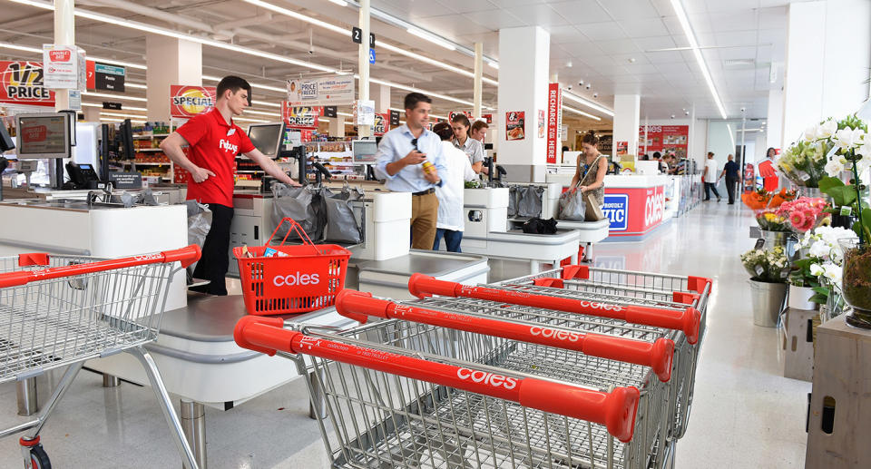 Coles trolleys, staff and customers at checkout area