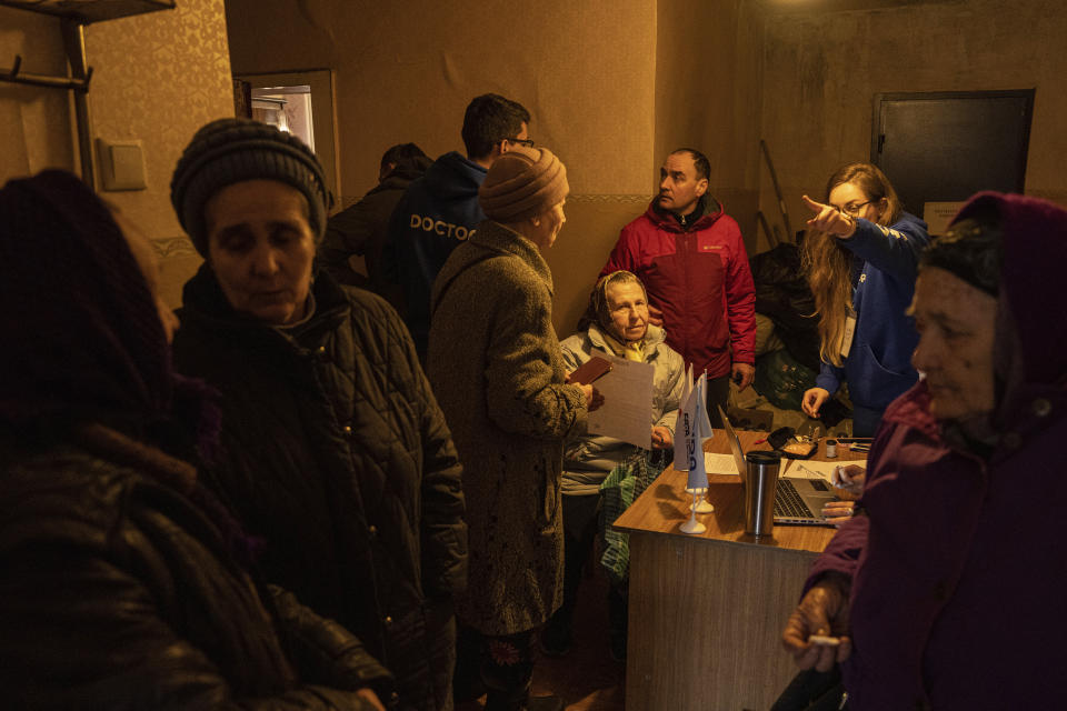 People wait in the corridor to visit doctors of FRIDA Ukraine in Khrestysche village, Donetsk region, Ukraine, Sunday, March 19, 2023. The Ukrainian-Israeli medical aid organization FRIDA Ukraine, staffed by volunteer doctors, has been providing specialist medical care through mobile clinics in villages and towns near the front lines and in recently retaken areas. (AP Photo/Evgeniy Maloletka)