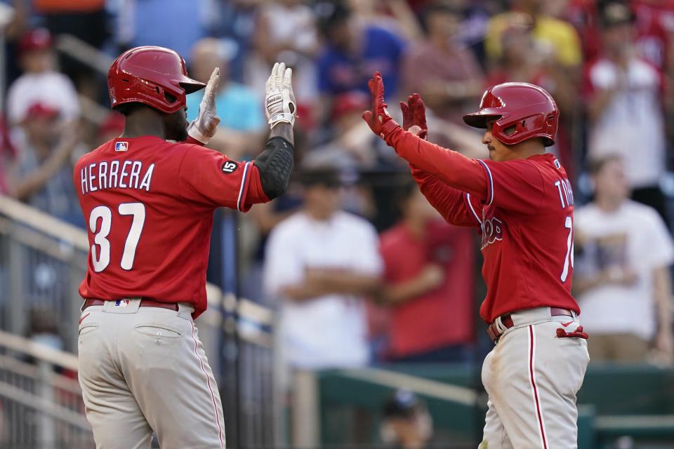 Philadelphia Phillies' Odubel Herrera, left, and Ronald Torreyes high-five after scoring on J.T. Realmuto's double in the ninth inning of a baseball game against the Washington Nationals, Thursday, Aug. 5, 2021, in Washington. Philadelphia won 7-6. (AP Photo/Patrick Semansky)