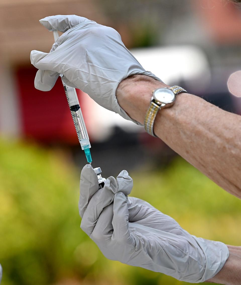 The COVID-19 vaccine is drawn from a vial during an outdoor clinic at the Davis Thayer Elementary School in Franklin, Aug. 25, 2021.