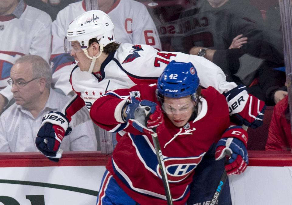 Washington Capitals defenseman John Carlson (74) is checked into the boards by Montreal Canadiens right wing Sven Andrighetto (42) during the second period of an NHL hockey game Monday, Jan. 9, 2017, in Montreal. (Paul Chiasson/The Canadian Press via AP)