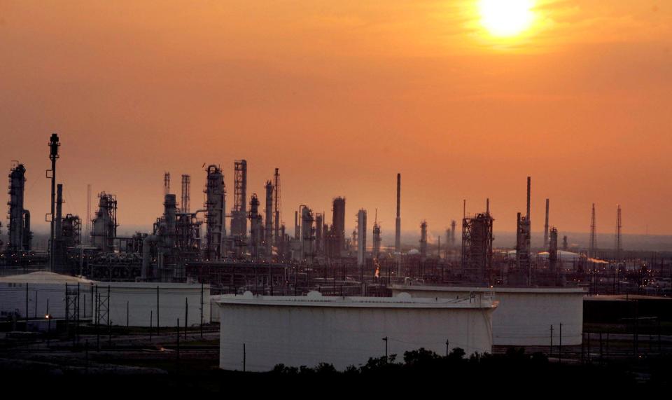 The sun begins to set over an oil refinery in Port Arthur, Texas, in this May 17, 2007 file photo.