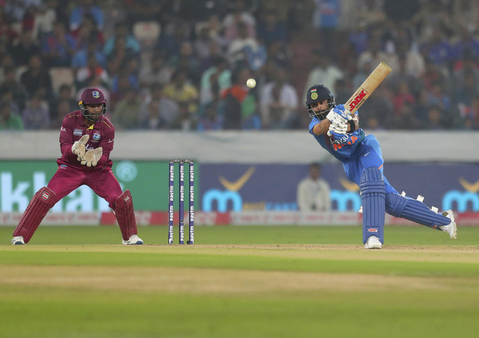 India's captain Virat Kohli, right, plays a shot during the first Twenty20 international cricket match between India and West Indies in Hyderabad, India, Friday, Dec. 6, 2019. (AP Photo/Mahesh Kumar A.)