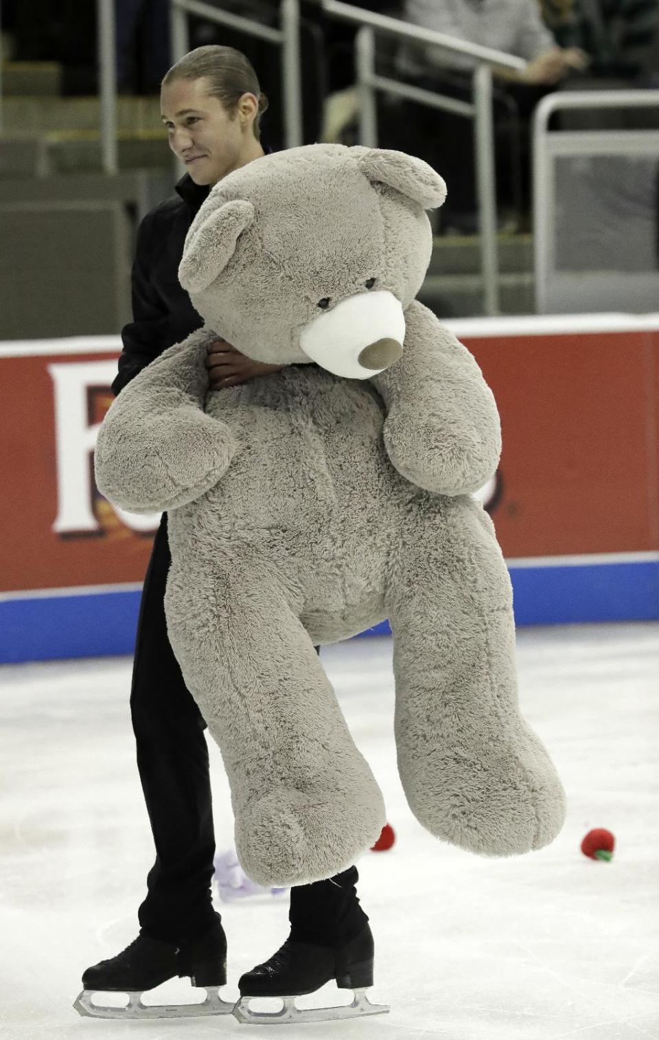 Jason Brown carries a stuffed bear off the ice after his performance in the men's free skate competition at the U.S. Figure Skating Championships, Sunday, Jan. 22, 2017, in Kansas City, Mo. (AP Photo/Charlie Riedel)