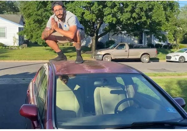 Matt Mullen poses atop his Honda Civic that he purchased in 2021. It was stolen two weeks ago as he helped a man who had collapsed on Kings Highway in Cherry Hill.