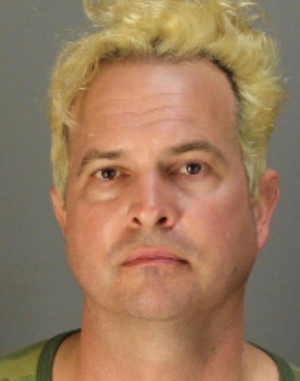 A man with bleached hair in a mug shot