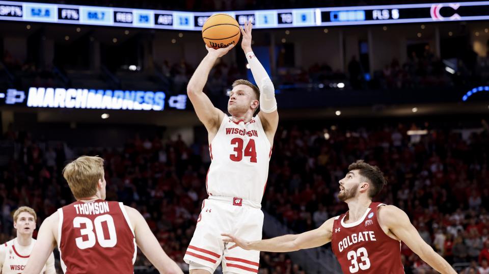 Mar 18, 2022; Milwaukee, WI, USA; Wisconsin Badgers guard Brad Davison (34) shoots the ball against Colgate Raiders guard Oliver Lynch-Daniels (33) in the second half during the second round of the 2022 NCAA Tournament at Fiserv Forum. Mandatory Credit: Jeff Hanisch-USA TODAY Sports