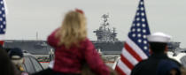 Family and Navy personnel watch as the nuclear aircraft carrier Harry S. Truman approaches the pier at Naval Station Norfolk in Norfolk, Va., Friday, April 18, 2014. The Carrier Strike Group returned from a 9-month deployment to the Middle East. (AP Photo/Steve Helber)