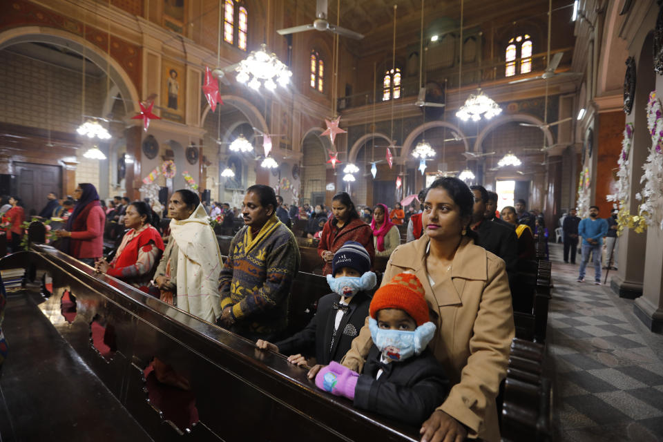 Indian Christians, some wearing face masks as a precaution against the coronavirus, attend a Christmas mass at St. Joseph's Cathedral in Prayagraj, India. Friday, Dec. 25, 2020. (AP Photo/Rajesh Kumar Singh)